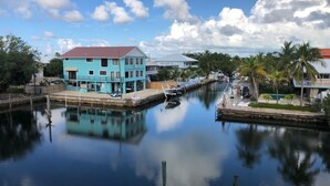 A calm waterway with a blue building and a dock. - Re-energize at our spacious condo! Enjoy 10% off stays of 7+ days. Book now! (Key Largo)