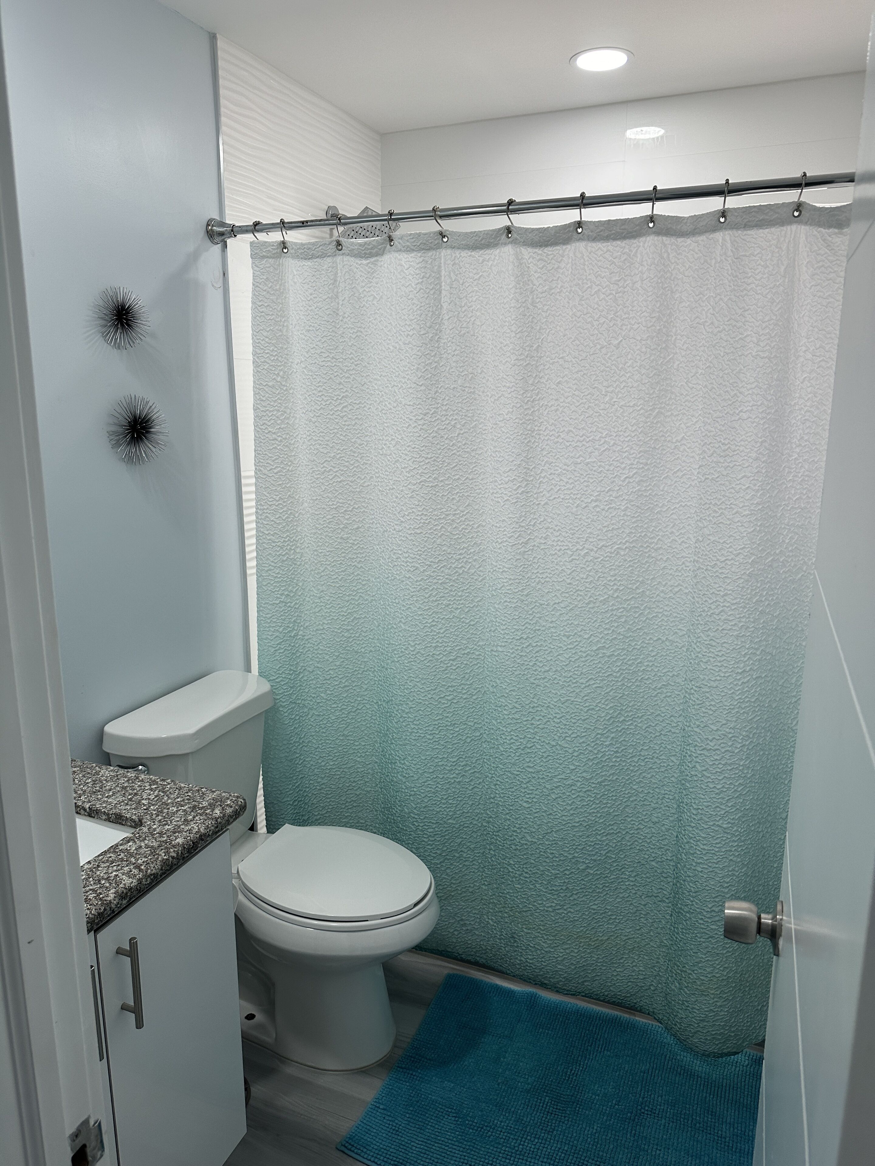 A bathroom with a toilet, a sink, and a shower curtain.