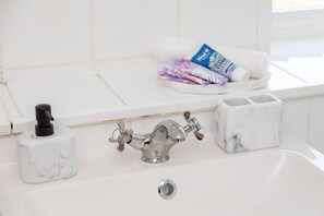 Een bad/douchecombinatie, een haardroger, handdoeken