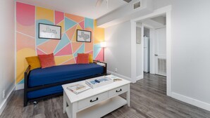 A bedroom with a bed, a white nightstand, a colorful geometric wall, and a ceiling fan. - CentralCozy1BDR+PetsOK+Extended Stay Discount (Corpus Christi)