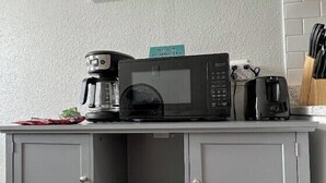 A kitchenette with a microwave, coffee maker, and a framed picture on the wall. - CentralCozy1BDR+PetsOK+Extended Stay Discount (Corpus Christi)
