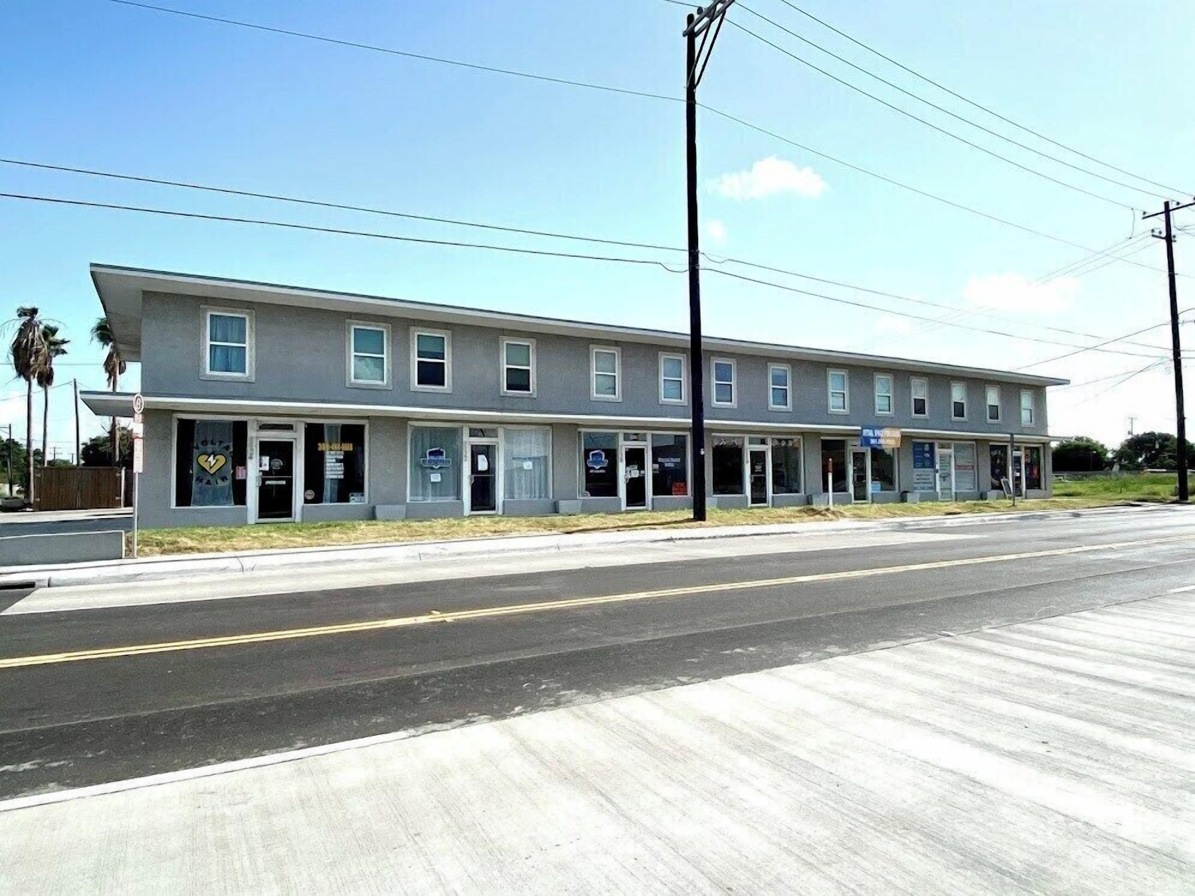 A two-story motel with a row of rooms on the ground floor and a small storefront on the second floor.