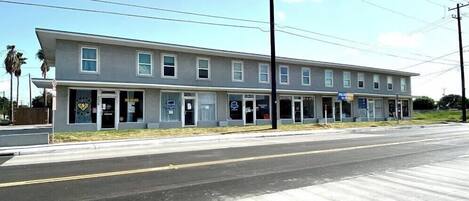 A two-story motel with a row of rooms on the ground floor and a small storefront on the second floor.