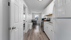 A narrow hallway with white doors leading to a kitchen area. - CentralCozy1BDR+PetsOK+Extended Stay Discount (Corpus Christi)
