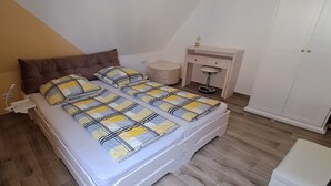 Un dormitorio con cama, mesita de noche, silla y armario.