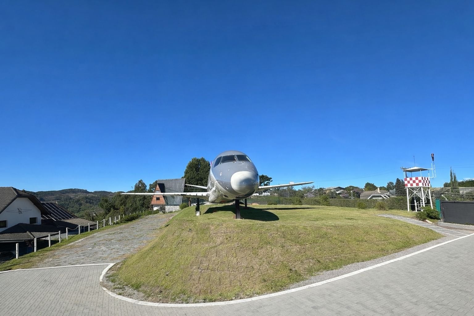 An airplane parked on a grassy area with a clear sky.