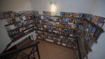 Uma escadaria em espiral com estantes de livros em cada lado, dando acesso a um andar superior.