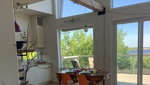 A modern kitchen with a large island, yellow stools, and a view of the outdoors. - Modern family-sized chalet at private lake (Red Deer County)