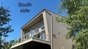 A modern building with a balcony and large windows. - Modern family-sized chalet at private lake (Red Deer County)