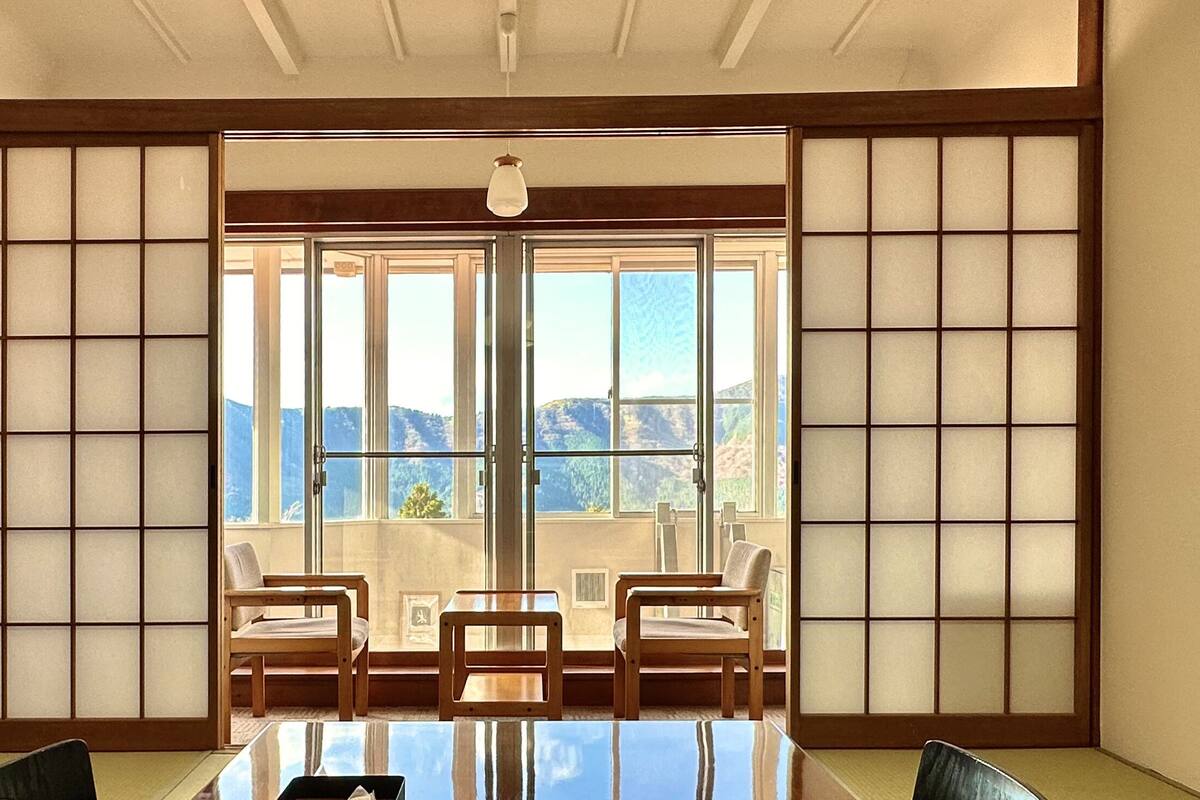 Une pièce de style japonais traditionnel, avec un sol recouvert de tatamis, une table basse et des portes coulissantes.