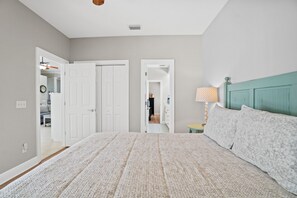 Ein Schlafzimmer mit einem großen Bett, einem Nachttisch mit Lampe und einem Kleiderschrank.
