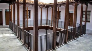 A courtyard with a central open space surrounded by columns and railings. - PALACIO BUENAVISTA LUXURY APARTMENTS 1.1. (Sevilla)