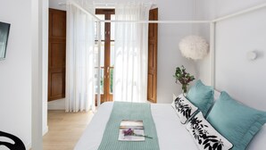 A bedroom with a bed, a window with curtains, a white wall, and a ceiling with wooden beams. - PALACIO BUENAVISTA LUXURY APARTMENTS 1.1. (Sevilla)