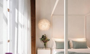 Une chambre à coucher avec un lit, une table de chevet et un luminaire suspendu.