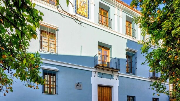 A multi-story building with balconies and a wooden door. - PALACIO BUENAVISTA LUXURY APARTMENTS B.2 (Sevilla)