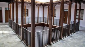 A courtyard with a central open space surrounded by columns and railings. - PALACIO BUENAVISTA LUXURY APARTMENTS B.2 (Sevilla)