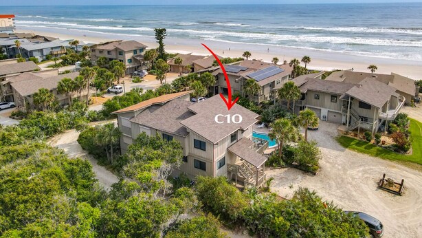Una zona residenziale sulla costa, con case, una spiaggia e una piscina.