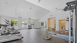 Une salle de sport spacieuse équipée de tapis de course, d’un rameur et de matériel d’haltérophilie.