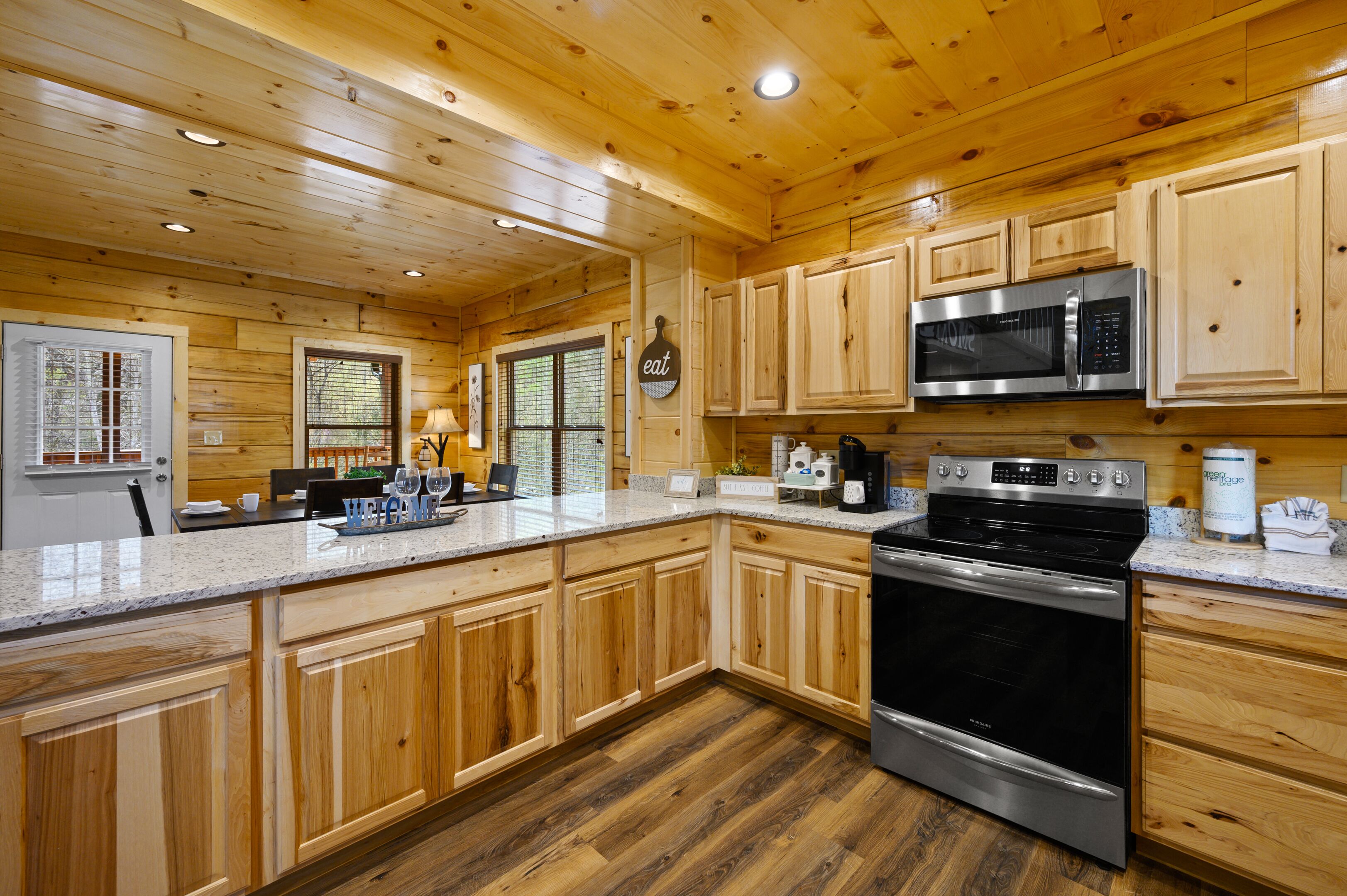 A modern kitchen with wooden cabinets, stainless steel appliances, and a granite countertop.
