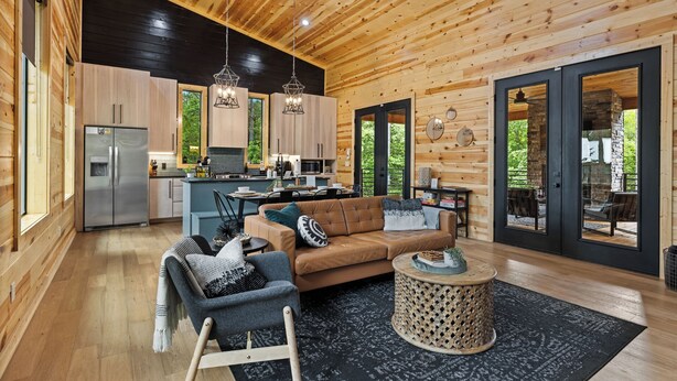 Ein modernes Blockhaus-Interieur mit Küche, Essbereich und Wohnzimmer.