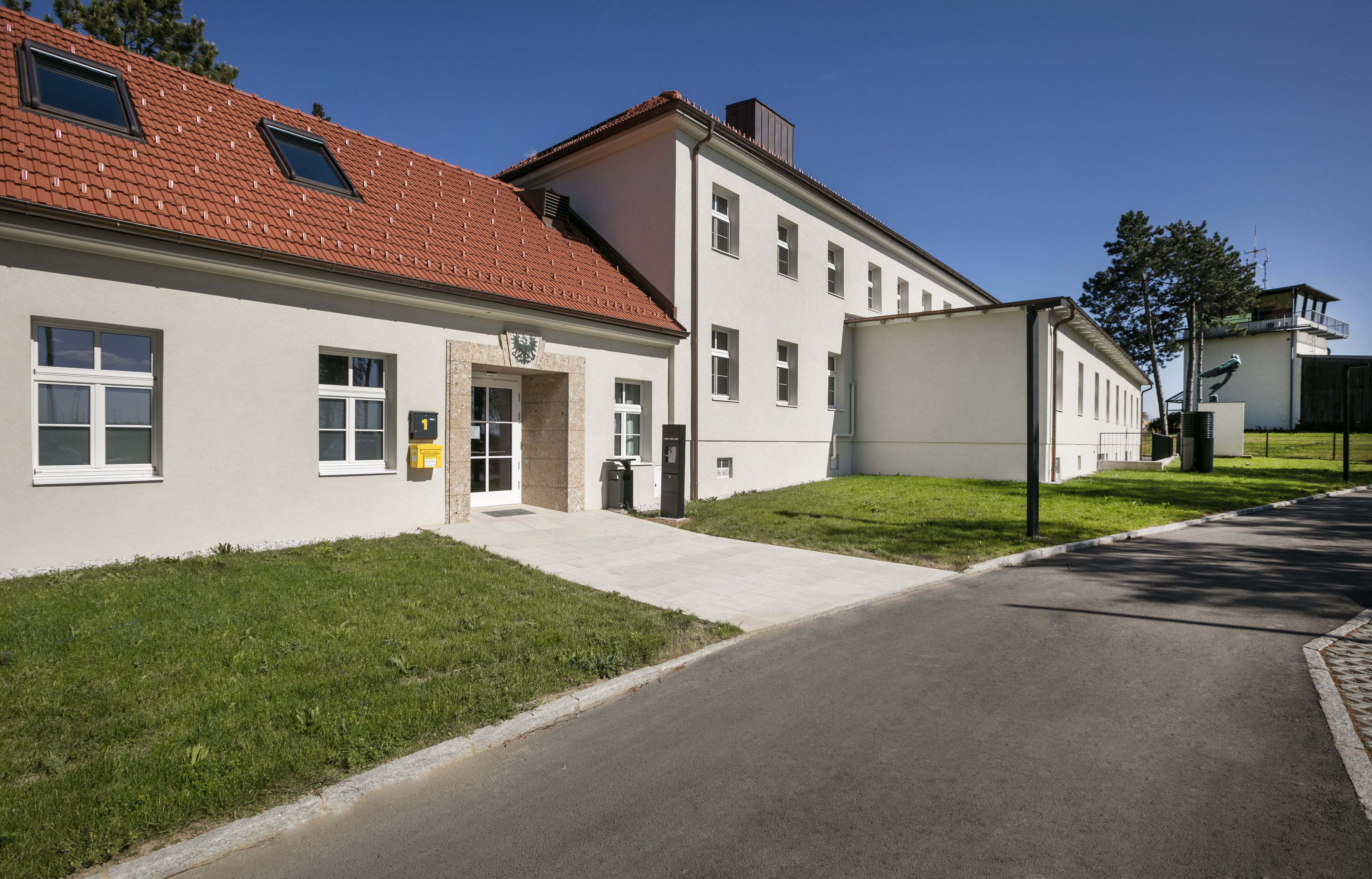 En byggnad med ett rött tegeltak, en stor skylt och en asfalterad uppfart.