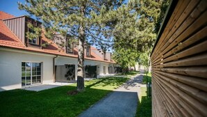Una zona residencial con un camino que lleva a una hilera de casas, cada una con un estilo arquitectónico diferente y un césped cuidado.