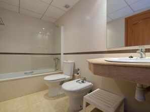 A bathroom with a shower, two toilets, a sink, and a mirror. - Golden Beach by Interhome (St Carles de la Ràpita)