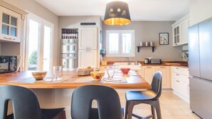 Una cocina moderna con una isla central, electrodomésticos de acero inoxidable y una lámpara colgante.