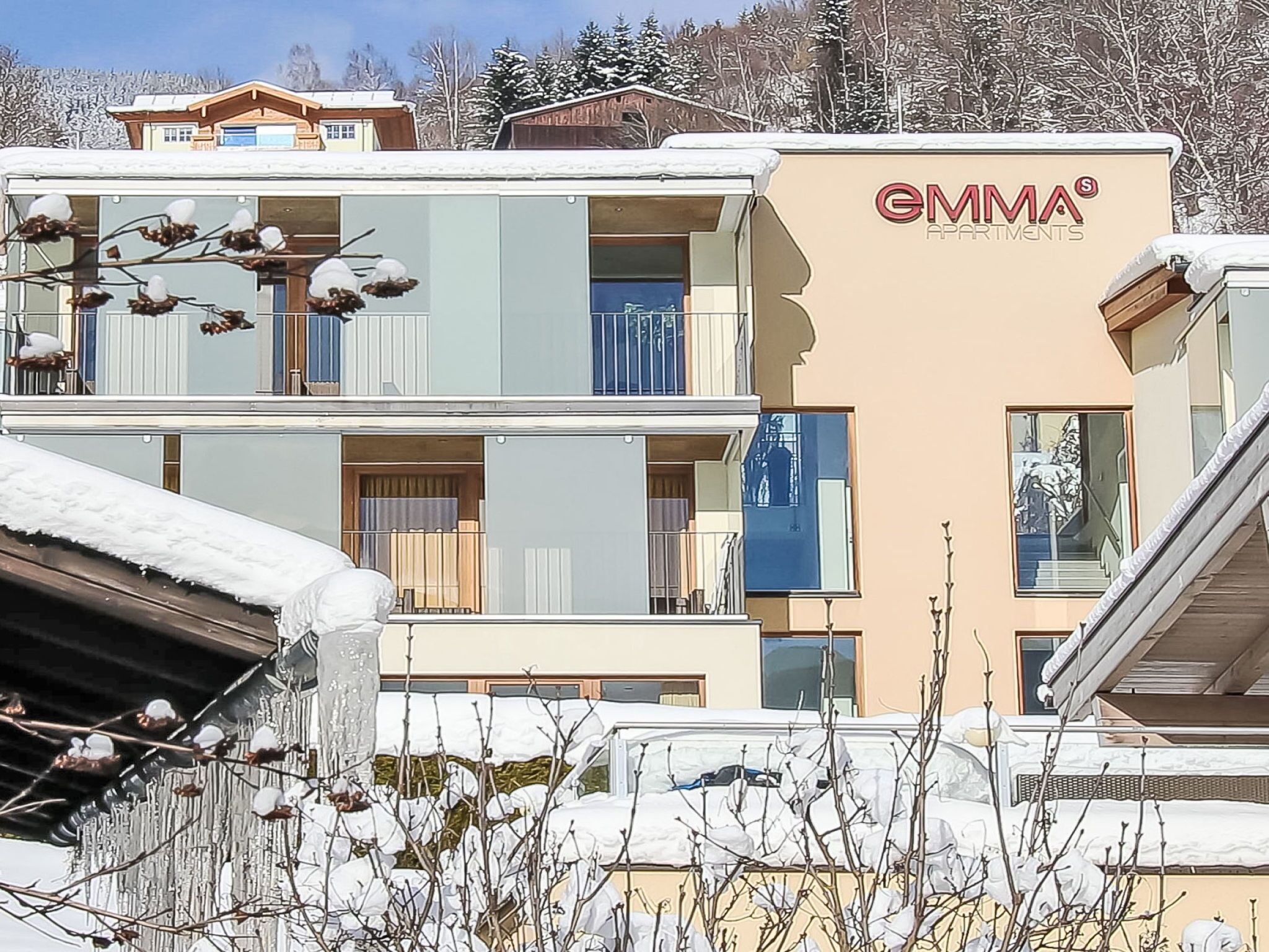 A multi-story building with balconies and a sign reading "GMM Apartments".