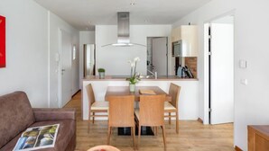 A modern apartment with a dining area, kitchen, and living room. - Apartment Emma by Interhome (Kaprun)