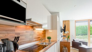 A modern kitchen with wooden accents, a built-in stove, and a sink. - Apartment Emma by Interhome (Kaprun)