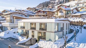 A modern hotel with a glass facade, located in a snowy mountainous area. - Apartment Emma by Interhome (Kaprun)