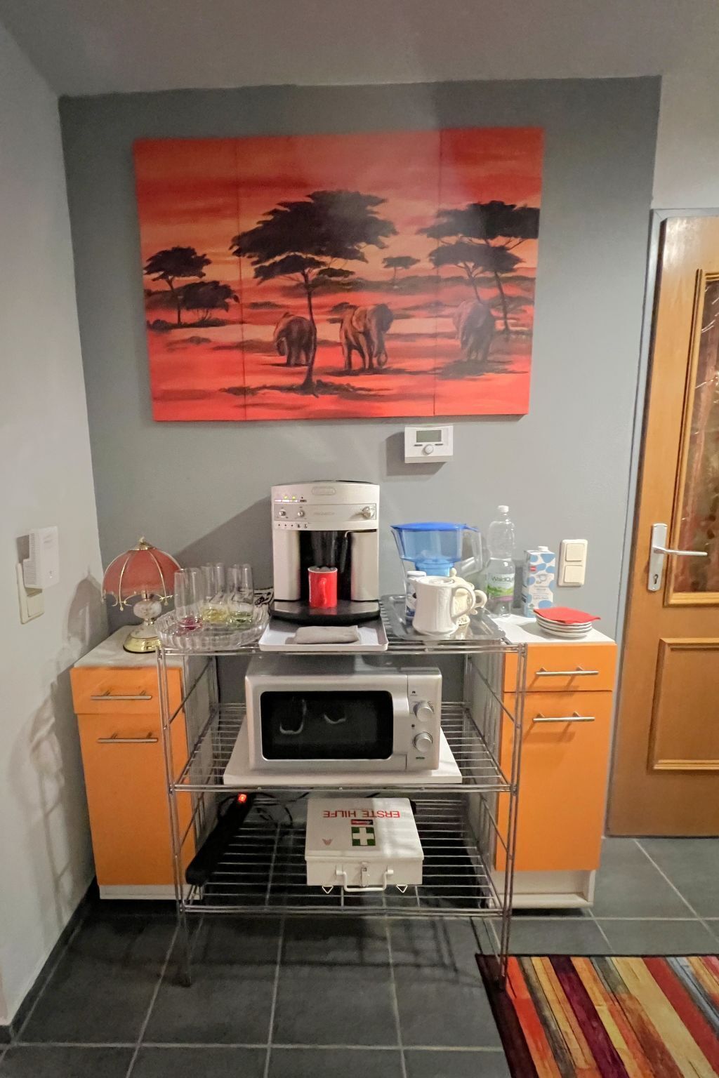 A kitchenette with a coffee maker, microwave, and a first aid kit.