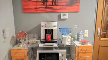 A kitchenette with a coffee maker, microwave, and a first aid kit.