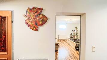 Una habitación con radiador, suelo de madera y cama con colcha estampada.