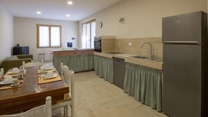 Une cuisine moderne avec un coin repas, un réfrigérateur et un évier.
