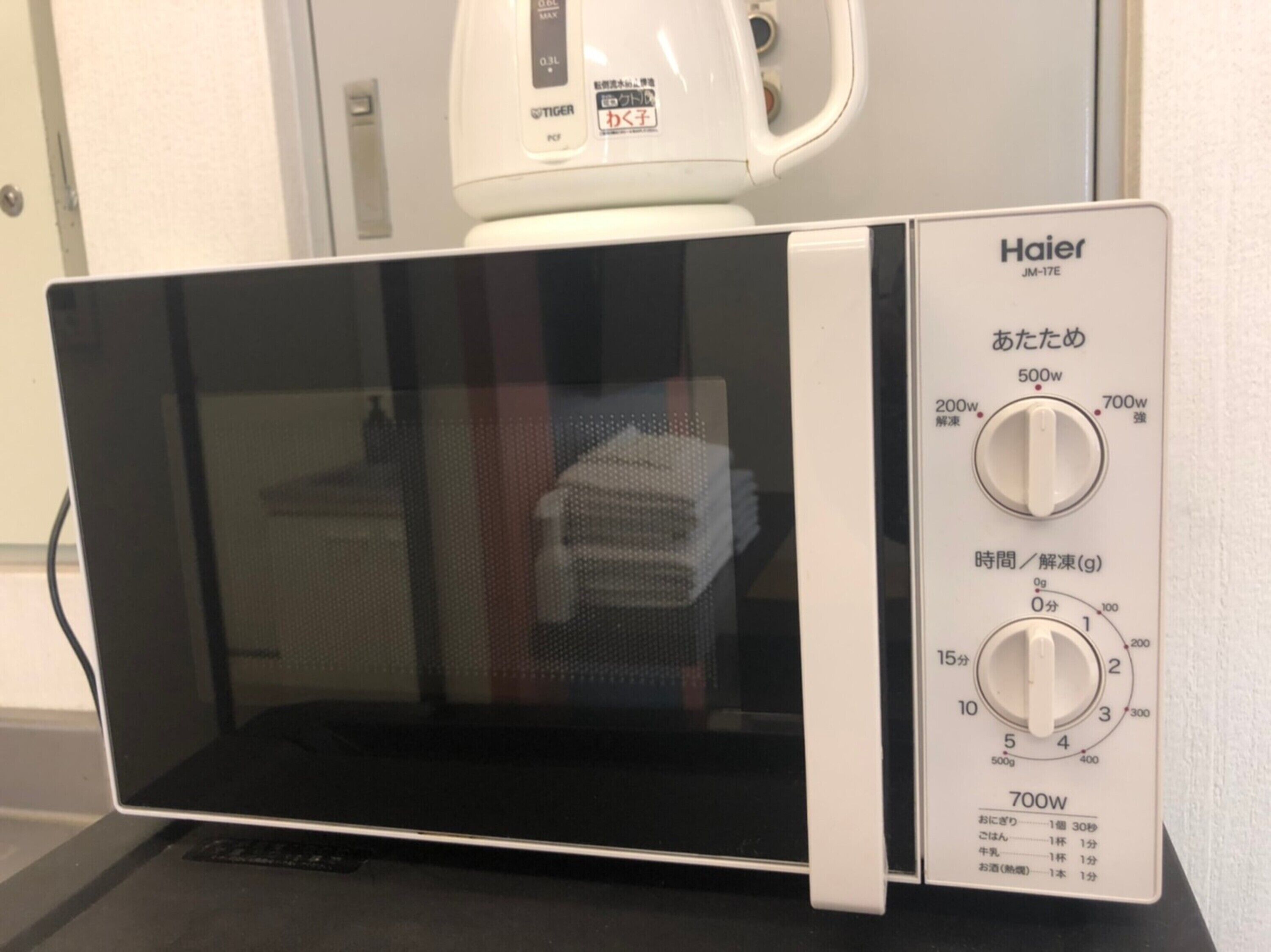 A Haier microwave oven with a digital display and control knobs for power and time settings.