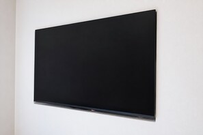 Televisão de tela plana fixada na parede.