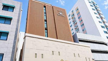 A hotel building with a modern facade, a prominent logo, and a sign indicating 'Centro Stay.'