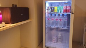 A refrigerator stocked with beverages and a speaker on a shelf. - CentroStay (Incheon)