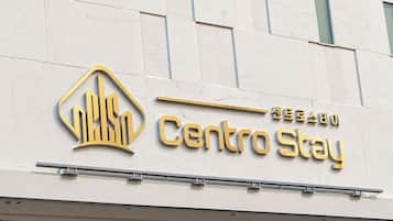 A hotel sign with the name 'Centro Stay' and a stylized building icon.