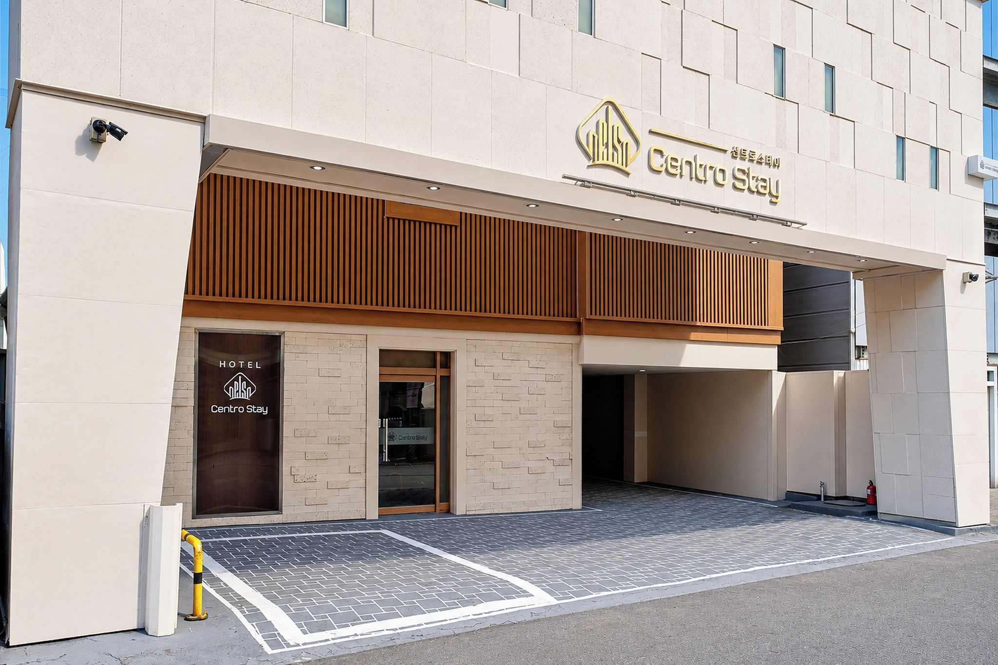 A hotel entrance with a sign reading 'Centro Stay' and a visible fire extinguisher.