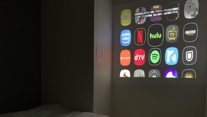 A hotel room with a bed and a wall displaying various streaming service icons. - COB HOTEL ASAKUSA (Tokyo)