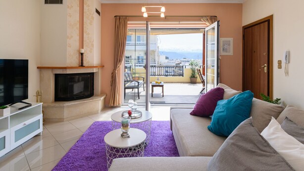 Un salon avec une cheminée, un canapé et un balcon offrant une vue agréable.