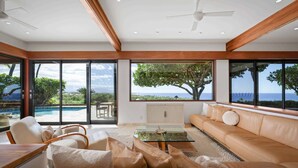 Ein stilvolles Wohnzimmer mit großem Fenster, einer Couch und einem Couchtisch.