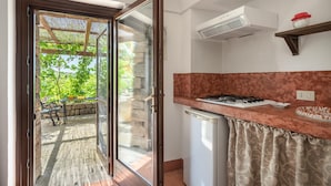 Una cocina con puerta de vidrio que da a un patio exterior, lavavajillas integrado y encimera roja.