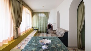 Une pièce avec une longue table, un canapé et une cheminée.