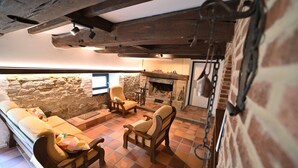 Una habitación acogedora con pared de piedra, chimenea y mobiliario de madera.