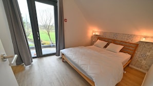 Un dormitorio con cama, ventana y puerta.