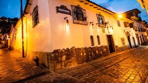 A historic building with a stone wall and a tiled roof, featuring a sign that reads "Casa do Convento." - Catama Inn Hotel (Cusco)